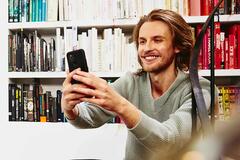man in library using smartphone