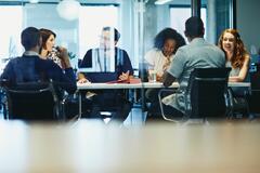 Group of colleagues sitting in a meeting room.