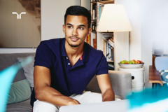 man in blue shirt sitting on couch in living room