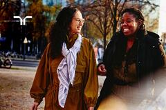 two women in a park having a conversation and smiling