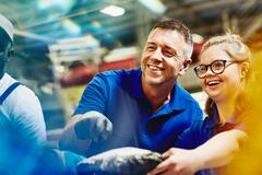 Man and woman looking at something while smiling. Man pointing at something.