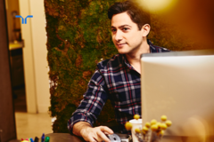 man at desk with computer looking offscreen