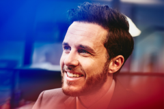 man smiling at his desk