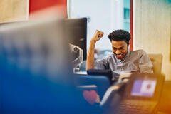 man cheering at his desk and smiling