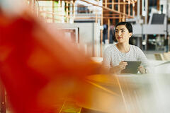 asian female sitting smiling working on laptop