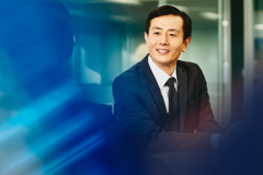 asian man smiling in a boardroom