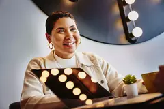 Female smiling sitting at a table with a laptop