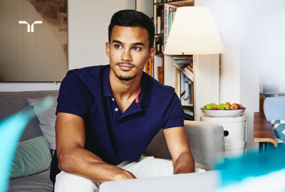 man in blue shirt sitting on couch in living room