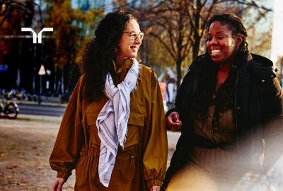 two women in a park having a conversation and smiling