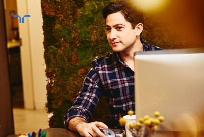 man at desk with computer looking offscreen
