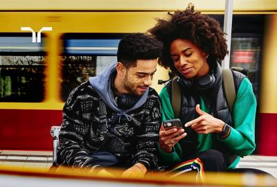 two people looking at a phone at a train station