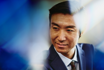 asian male standing and smiling in a suit