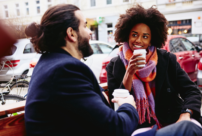 two friend enjoying a coffee on a bench