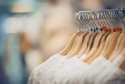 T-shirts on hangers. Shopping in store. Clothes on hangers in shop for sale. Fashionable clothes in a boutique. Various clothing on market.