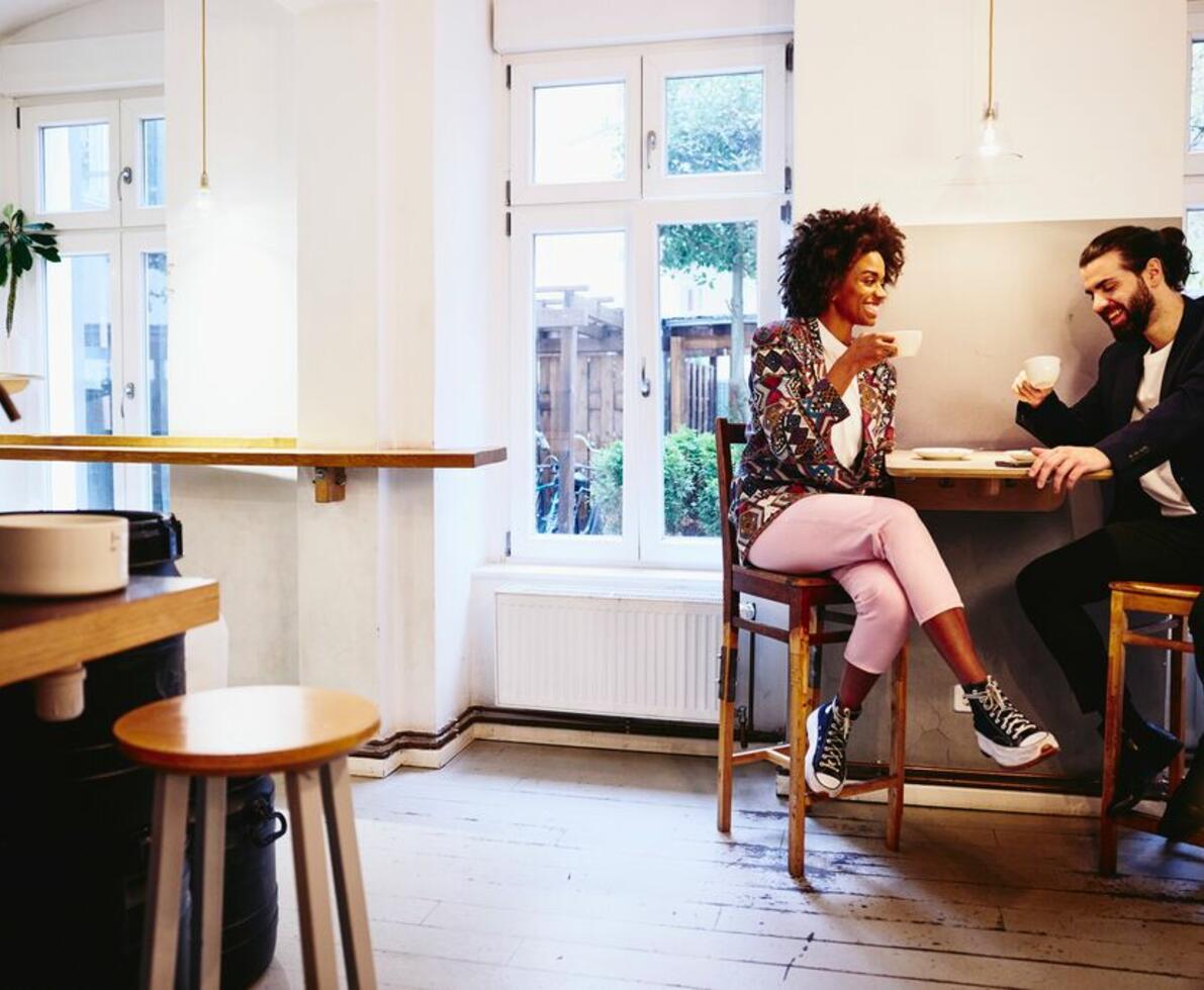 man and wonan discussing work over coffee