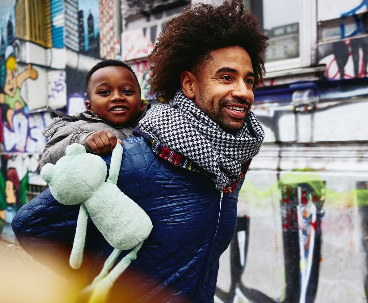 man carrying child on back