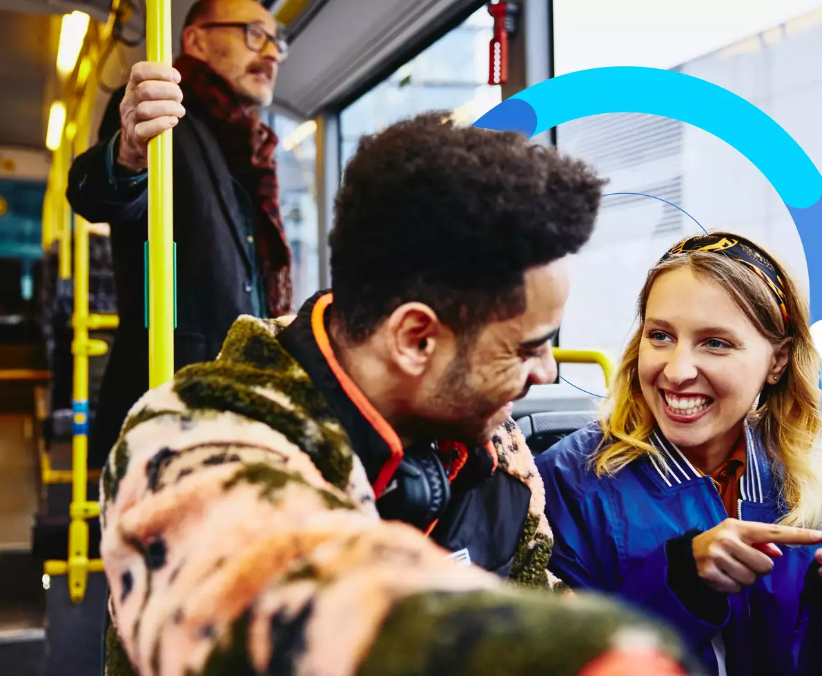 two people smiling talking on a bus
